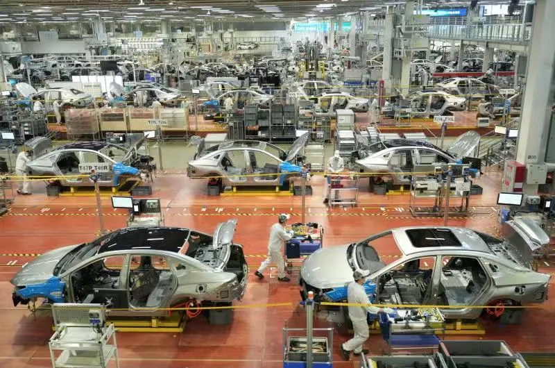 Vehicle bodies and workers inside the GAC Aion production hall in Panyu.