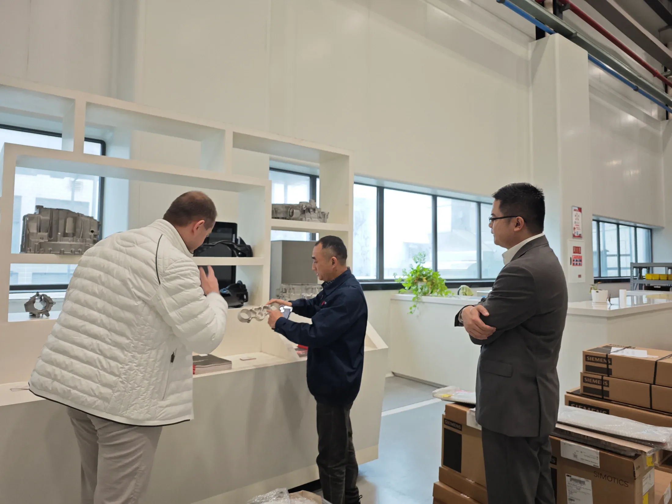 Technischer Austausch zu einem gefertigten Industriebauteil bei einem dokumentierten Besuch in Chongqing