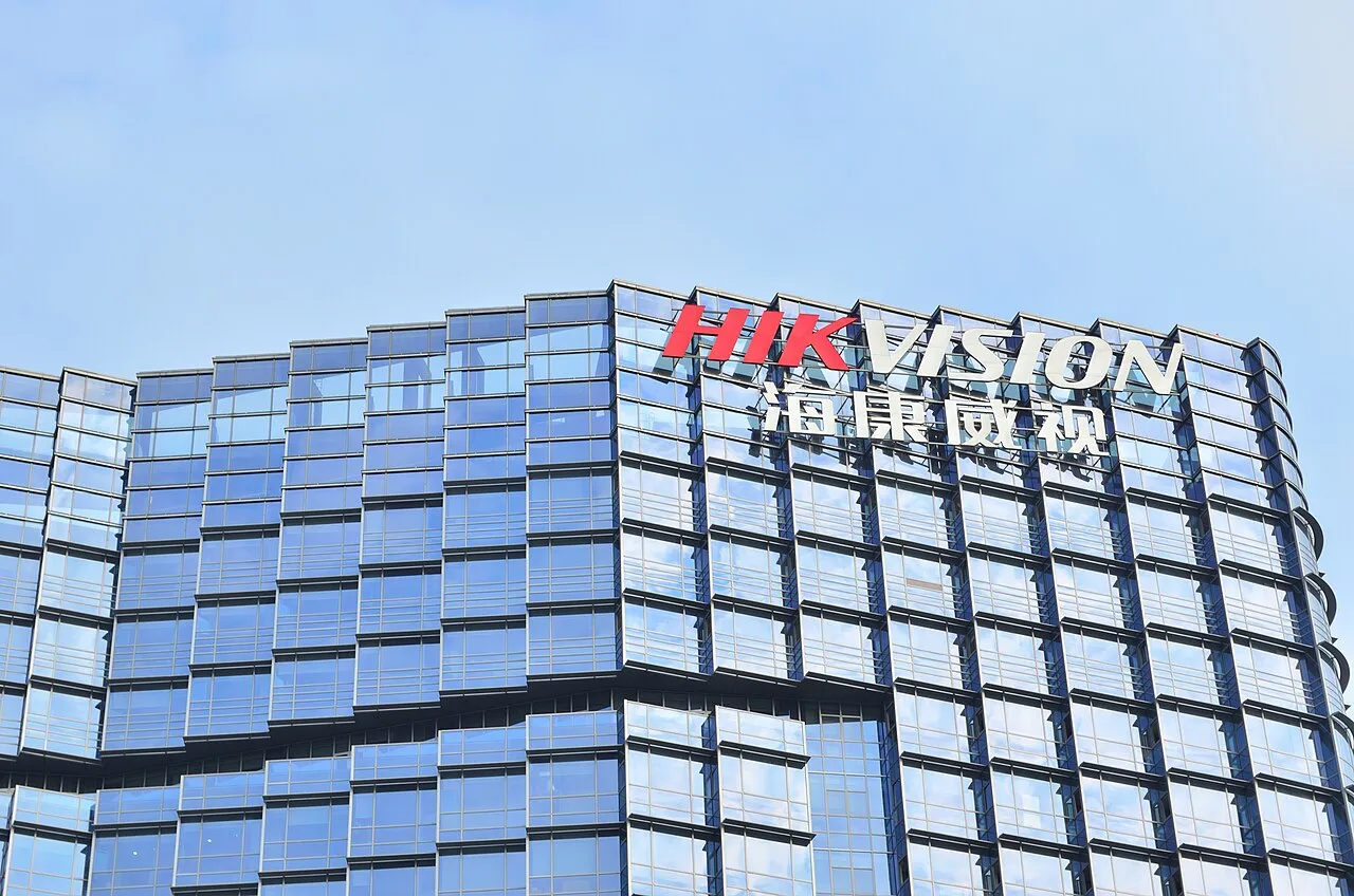 Glass façade bearing the Hikvision name against a blue sky.