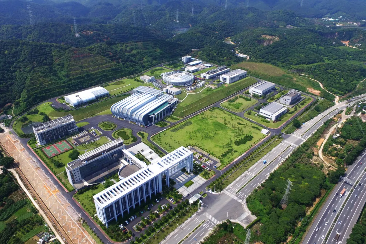 Aerial view of the CSNS research campus with experimental halls and a ring-shaped facility.