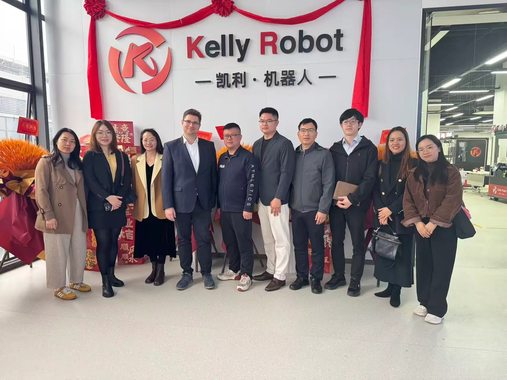 Besuchergruppe vor dem Schriftzug von Kelly Robot